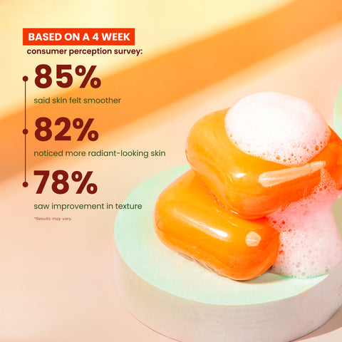 Two bars of Kojiwhite kojic acid and papaya skin brightening soap with fresh papaya slices, highlighting natural skin brightening ingredients.
